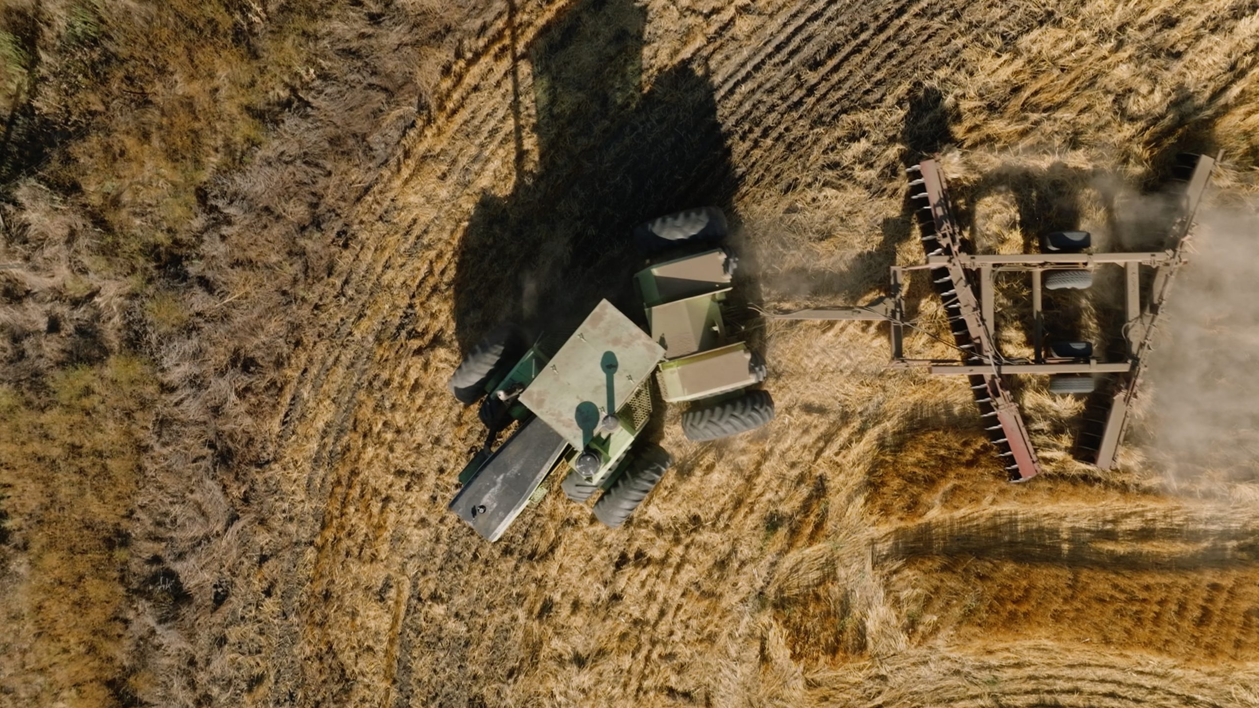 Bird's eye view of a tractor ploughing a wheat field – representing the agricultural operations that Agriware's farm operations software helps manage efficiently, from machine hours tracking to compliance and cost control.